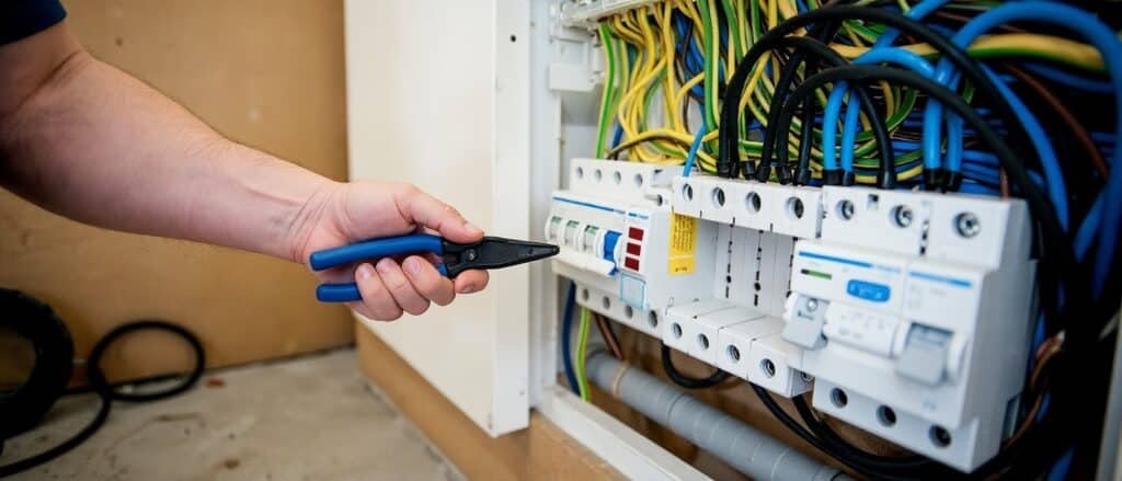 Electrician installing wiring for a home EV charger in a garage