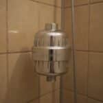 AquaBliss SF100 inline shower filter mounted on a shower arm