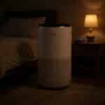 Levoit Core 400S-P air purifier beside a bedroom nightstand