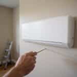 Homeowner installing an MRCOOL DIY 4th Gen indoor mini-split unit on an interior wall
