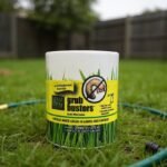 Nema Globe Grub Busters canister on a backyard lawn next to a garden hose