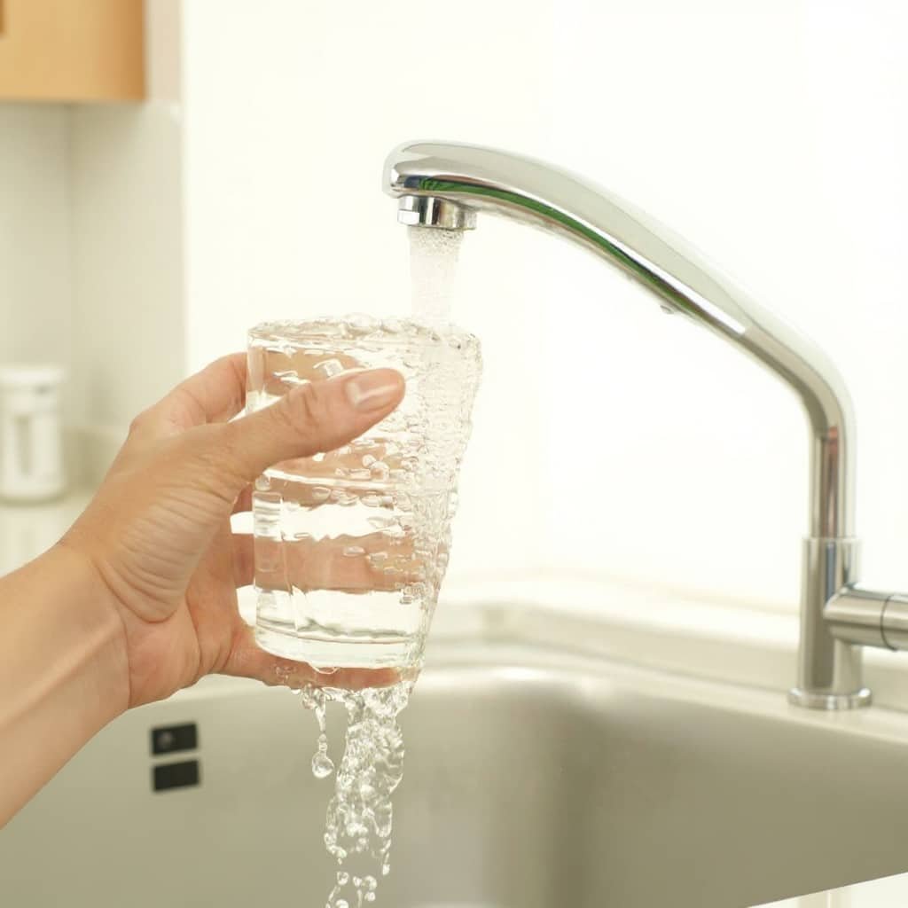 Best Under Sink Water Filter — Filling a glass of water at a kitchen tap