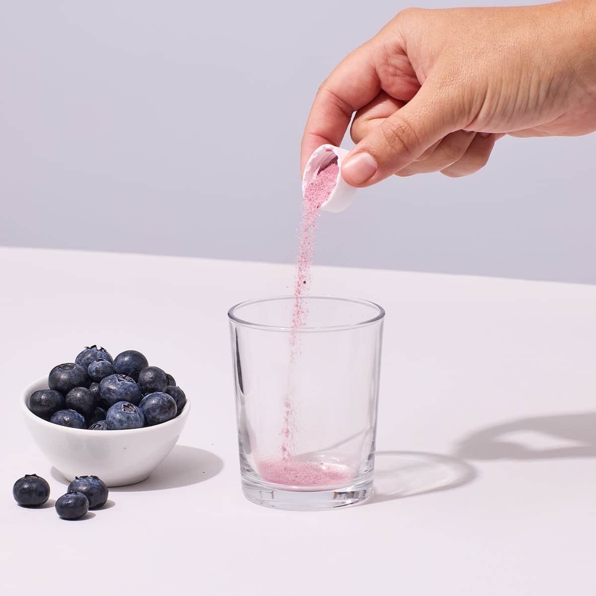 Pouring a serving of Isotonix OPC-3 Beauty Blend powder into a glass
