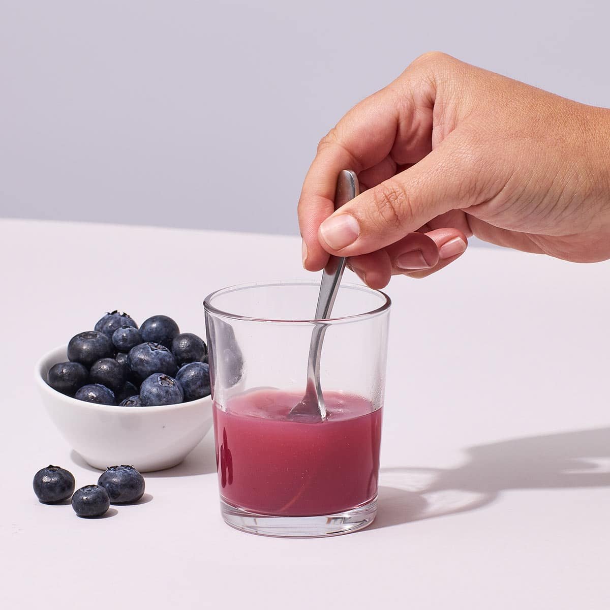 Mixing Isotonix OPC-3 Beauty Blend with water in a glass