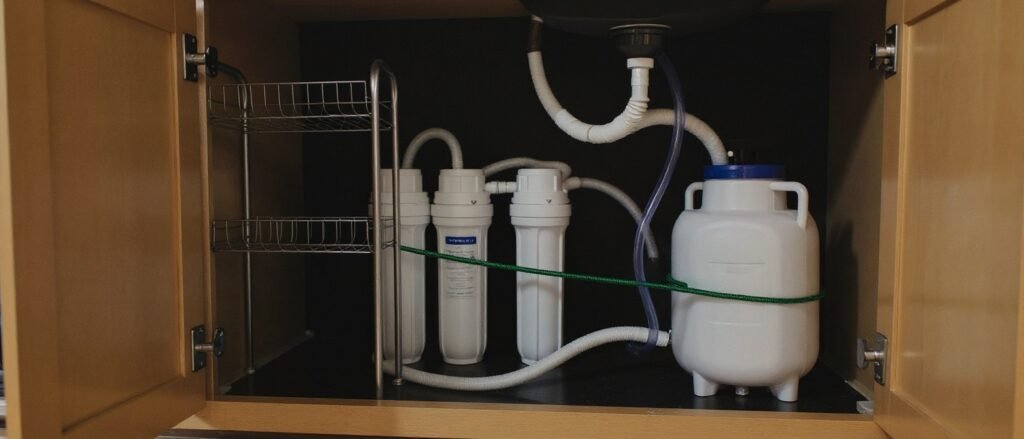 Under-sink reverse osmosis water filter system installed beneath a kitchen sink
